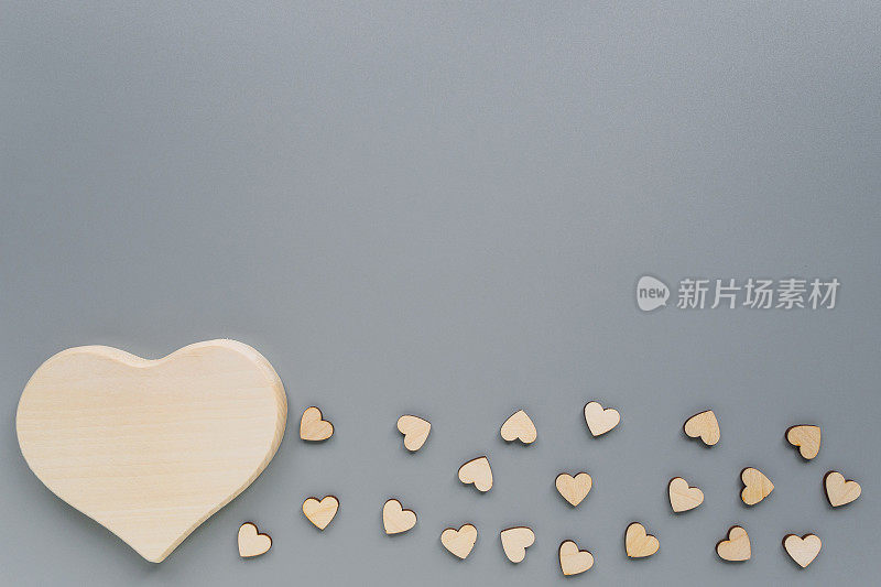 Mock-up of a wooden big heart and small hearts for Valentine's day. Wooden hearts on a grey background with Kopi space